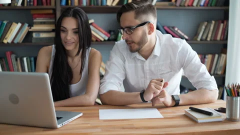 Two students brainstorm work by discuss with desktop in trendy loft close up wit Stock Footage 199491582