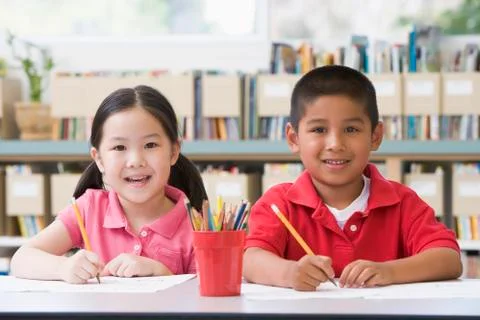 Two students in class writing Stock Photos
