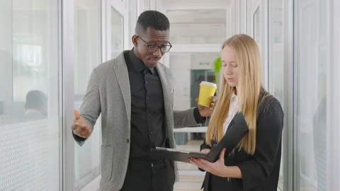 Two students diverse race and nationality work and study together, discuss paper Stock Footage 214336420