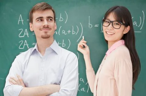 Two students doing math formula on the chalkboard, Beijing Foto stock