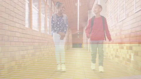 Two students entering hall heading to class, talking, adjusting backpacks while Stock Footage 333936631