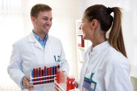Two students holding tubes and talking about science work Stock Photos