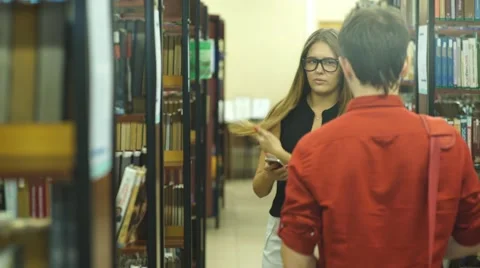 Two students met in the College library and discuss the lecture Stock Footage 68572040