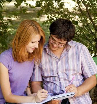 Two students at outdoor doing homework. Stock Photos