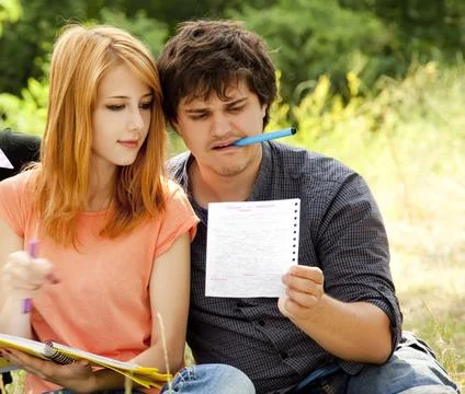 Two students at outdoor doing homework. Stock Photos