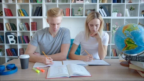 Two students preparing for exam in campus library Stock Footage 104427177