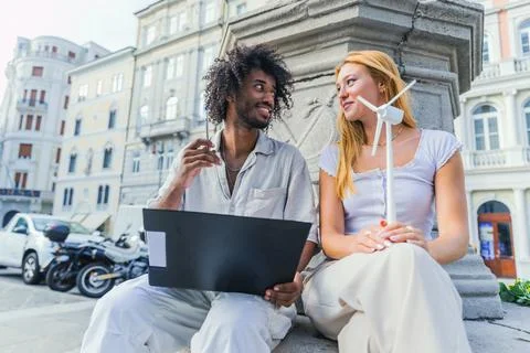 Two students study renewable energy, one reading notes the other holding a .. Stock Photos