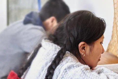 Two students study side by side at a wooden desk, the girl in the foreground Stock Photos
