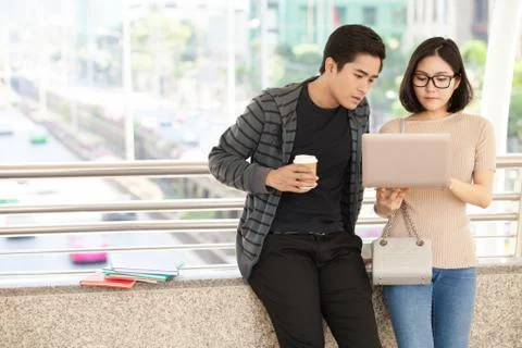Two students studying with computer notebook outdoors Stock Photos