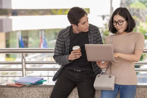 Two students studying with computer notebook outdoors Stock Photos