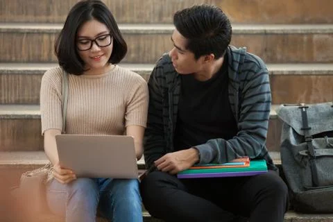 Two students studying with computer notebook outdoors Stock Photos
