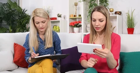 Two Students Woman Take Notes on Agenda Use Digital Tablet and Talking Home Sofa Stock Footage 83427126