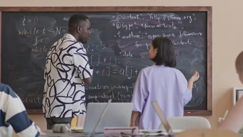 Two Students Writing Programming Code on Blackboard and Chatting Stock Footage 257067101