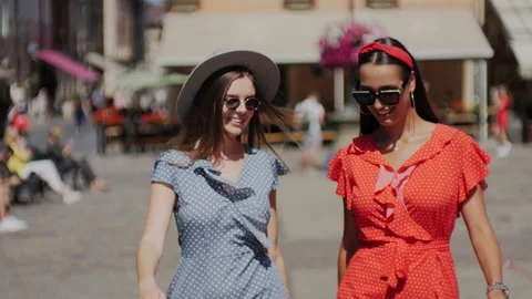 Two stylish girlfriends walking around the urban city, laughing and having fun. Video stock 138080094
