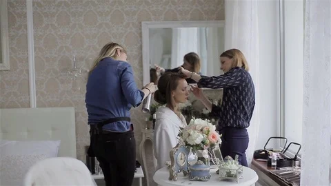Two stylists work on brides image look at same time on wedding morning Stock Footage 86968965