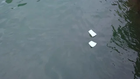 Two Styrofoam non-degradable cups floating in the ocean making pollution in the Stock Footage 146328281