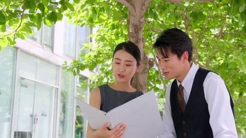 Two successful business professionals are seen smiling laughing while reviewing Stock Footage 328919610