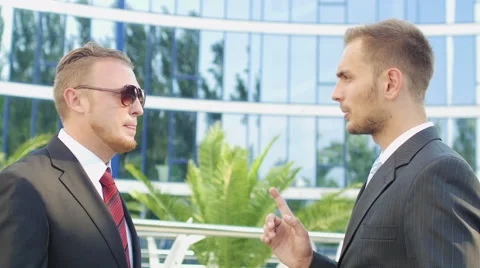 Two successful businessman talking while standing near office building Stock Footage 52820479