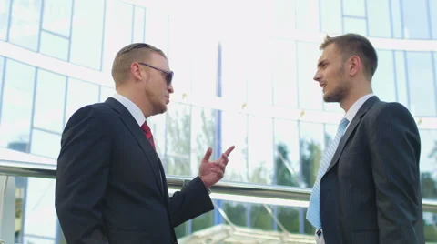 Two successful businessman talking while standing near office building Stock Footage 52821387