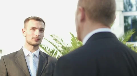 Two successful businessman talking while standing near office building Stock Footage 52821482