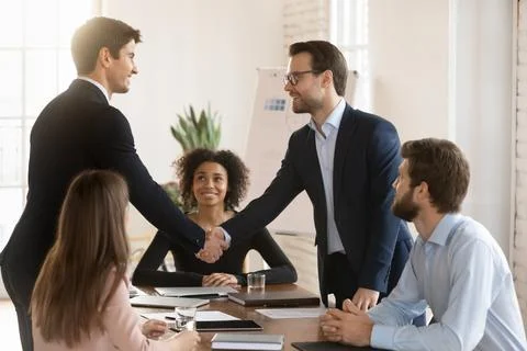 Two successful managers men in formal jackets greeting each other Stock Photos