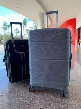 Two suitcases, hard shell and soft fabric travel suitcases with wheels, modern l Stock Photos