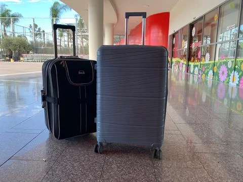 Two suitcases, hard shell and soft fabric travel suitcases with wheels, modern l Stock Photos