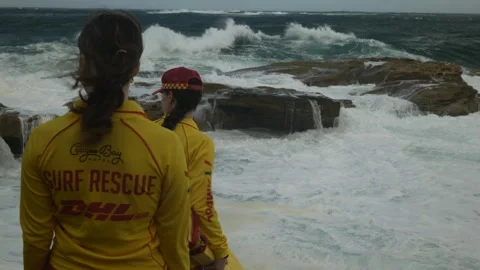 Two Surf Rescue female guards next to crashing waves in Sydney Coogee 6K Video stock 305426279