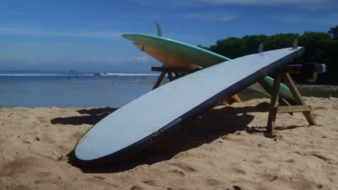 Two surfboards stacked on beach under sky, next to water Stock Footage 267184950