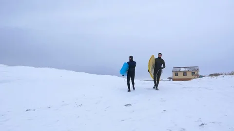 Two surfers go to the ocean in winter 002 Stock Footage 124768826