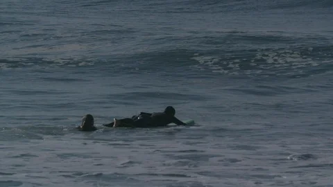 Two surfers going into the waves with a surfboard - Slow motion Video stock 105313252