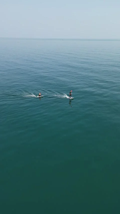 Two Surfers Riding Motorized Surfboards on the Ocean in Koh Phangan, Thailand Stock Footage 335815330