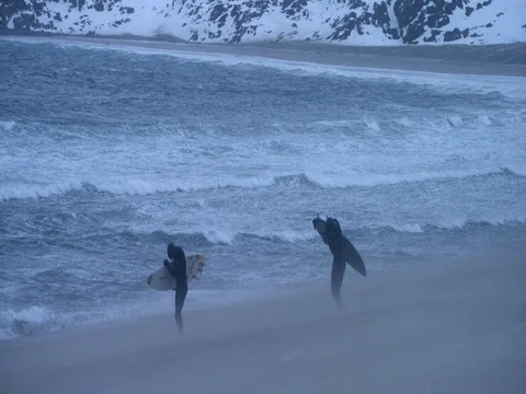 Two surfers running with surfboard on beach during high tide in slow motion 库存影片 73310328