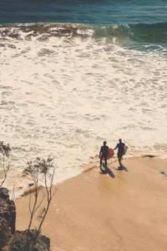 Two surfers walking into the water Stock Photos