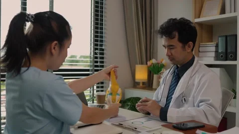 Two surgeons are sitting in a private office at a hospital discussing an upcomin Stock Footage 296747873