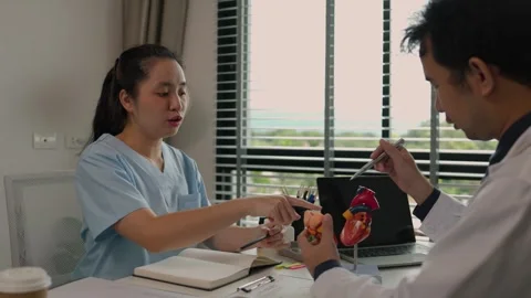 Two surgeons are sitting in their office discussing an upcoming major heart surg Stock Footage 296747805