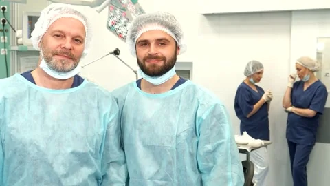 Two surgeons confidently pose in a bright surgery room Video stock 311946726