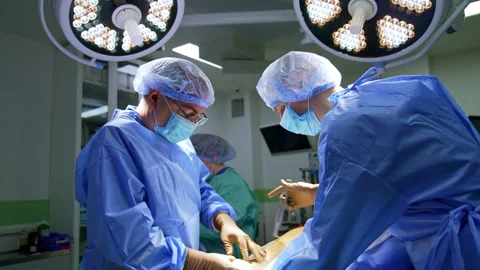 Two surgeons cooperate at trauma operation. Doctors use metal tools at procedure Stock Footage 342572706