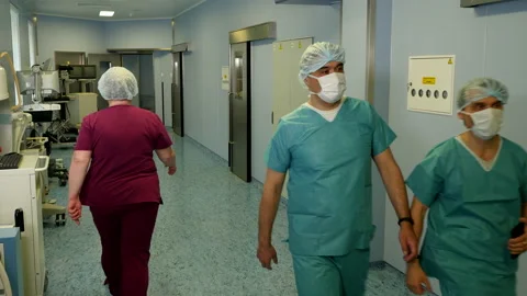 Two surgeons in masks walking through hospital operating block 스톡 동영상 107130680