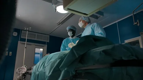 Two surgeons move an X-ray machine for surgery Stock Footage 127471558