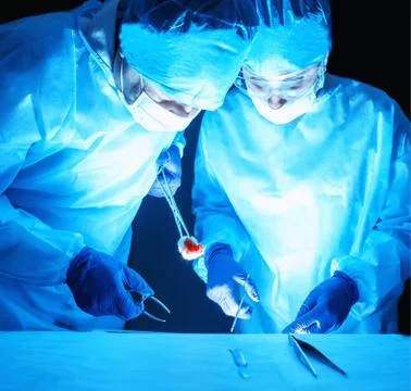 Two surgeons perform a complex operation to remove a cancer tumor. Oncology Stock Photos