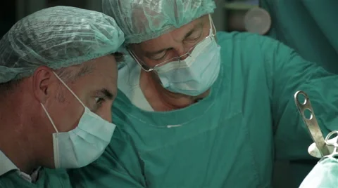 Two surgeons performing operation in hospital operating room, face close up. Video stock 50974495