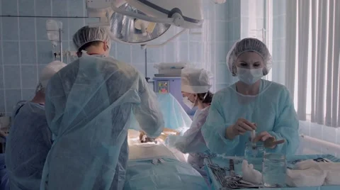 Two surgeons performing an operation together with surgical nurses Stockbeeldmateriaal 68930234