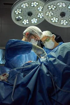 Two Surgeons Performing Surgery in an Operating Room Under Bright Lights Stock Photos