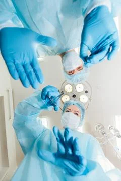 Two surgeons in protective uniform preparing for operation, looking at camera on Stock Photos