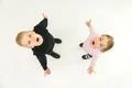 The two surprised children stand on the white background. View from above Photo