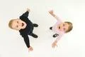 The two surprised kids stand on the white background. View from above Photo