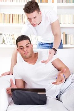Two surprised young people looking at laptop Stock Photos