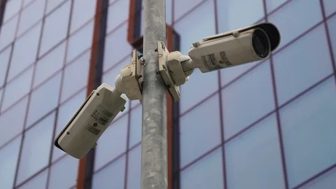 Two surveillance cameras on the light pole in front of the office building Stock Footage 106027966