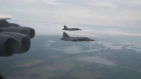 Two Swedish Air Force Saab JAS 39 Gripen aircraft flying on wing of B-52 bomber Stock Footage 213580337